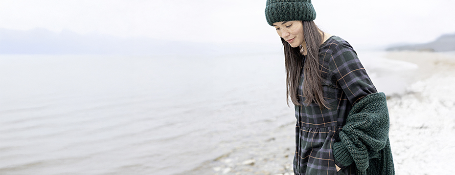 Frau am Meer mit grüner Wollmütze, Kleidung von Maas Naturwaren